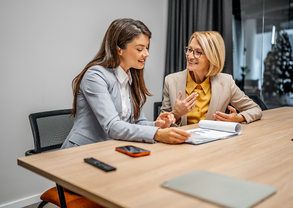 Insurance advisor providing personalised business insurance advice to a client during a professional meeting.